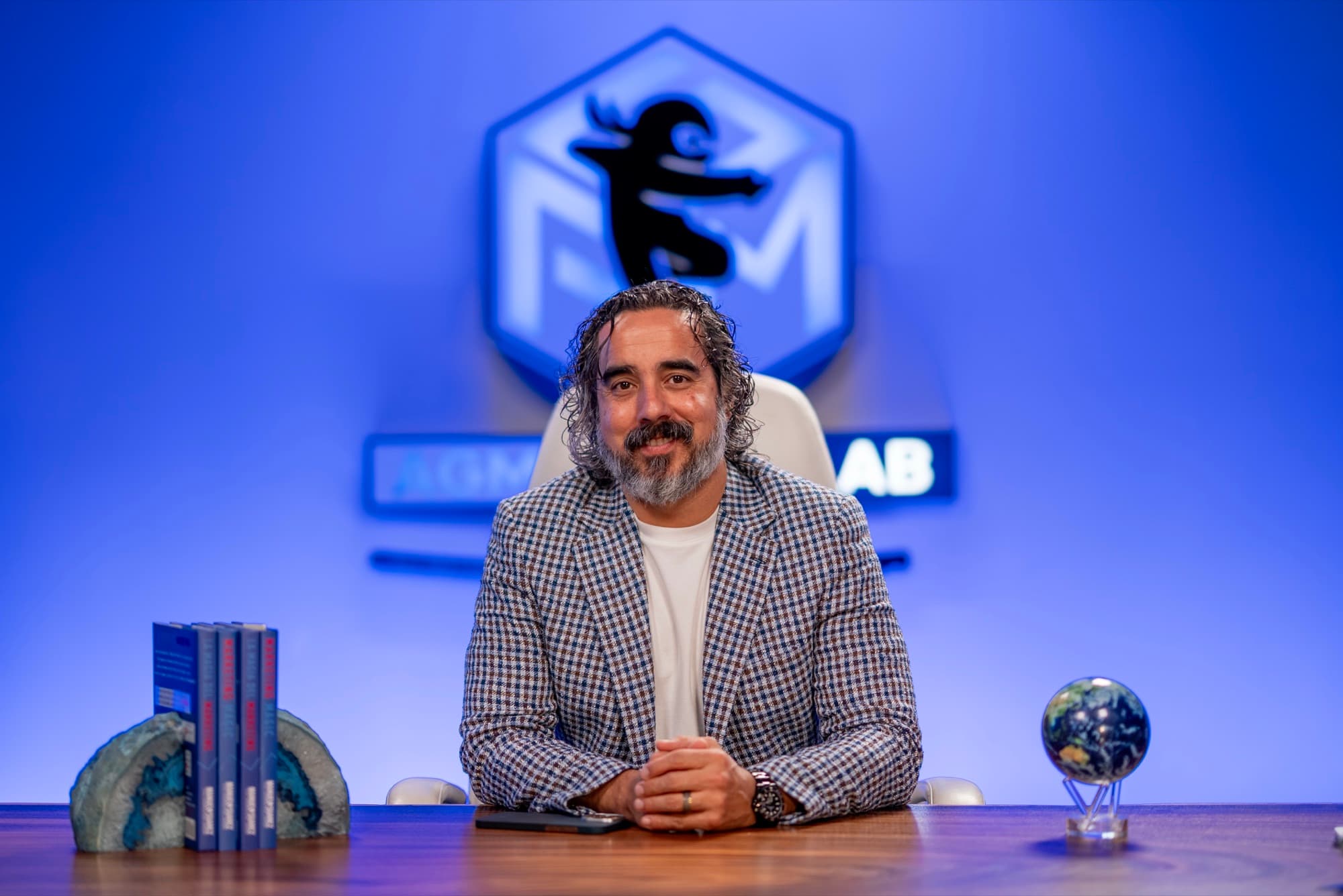 Manuel Suarez at his Ninja Lab desk, hands folded, facing the camera