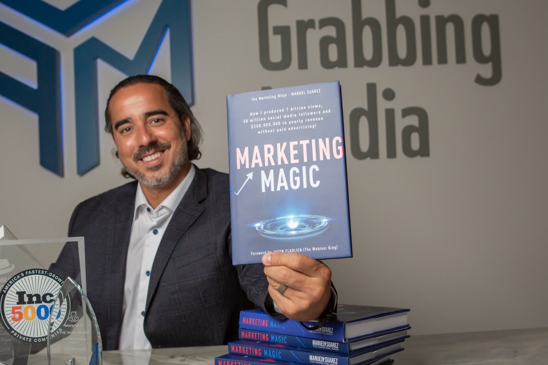 Manuel Suarez holding his book, Marketing Magic