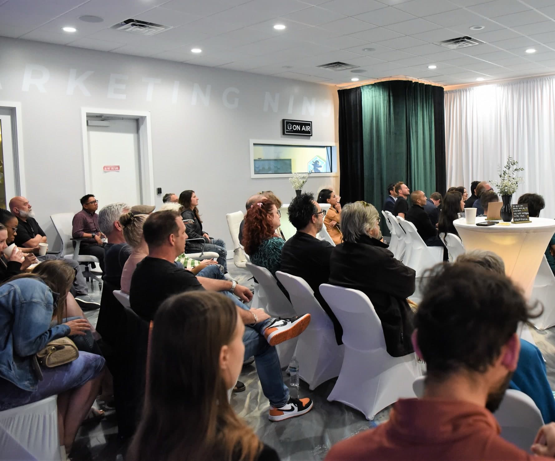 A full room of workshop attendees in white chair covers at the Largo, Florida studio