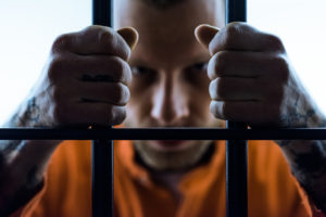 man in orange shirt in prison